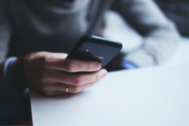 Person holding a phone while seeking guidance after someone dies in a Houston hospital