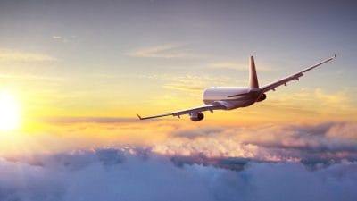 Airplane flying above clouds for families who need to travel with ashes on a plane.