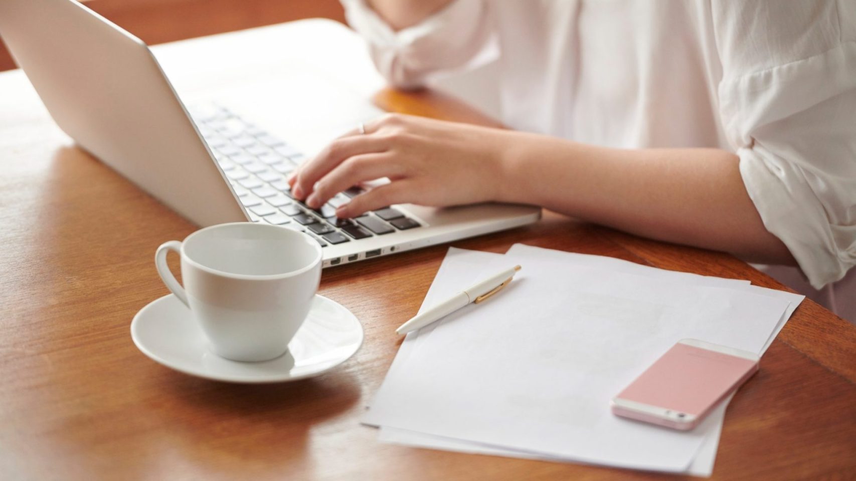 Person reviewing Birdsong cremation package options online with paperwork nearby