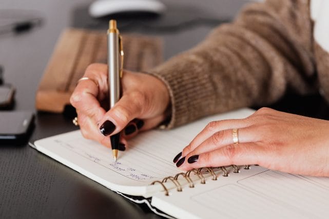 Person writing cremation arrangement notes for families handling cremation decisions in Texas