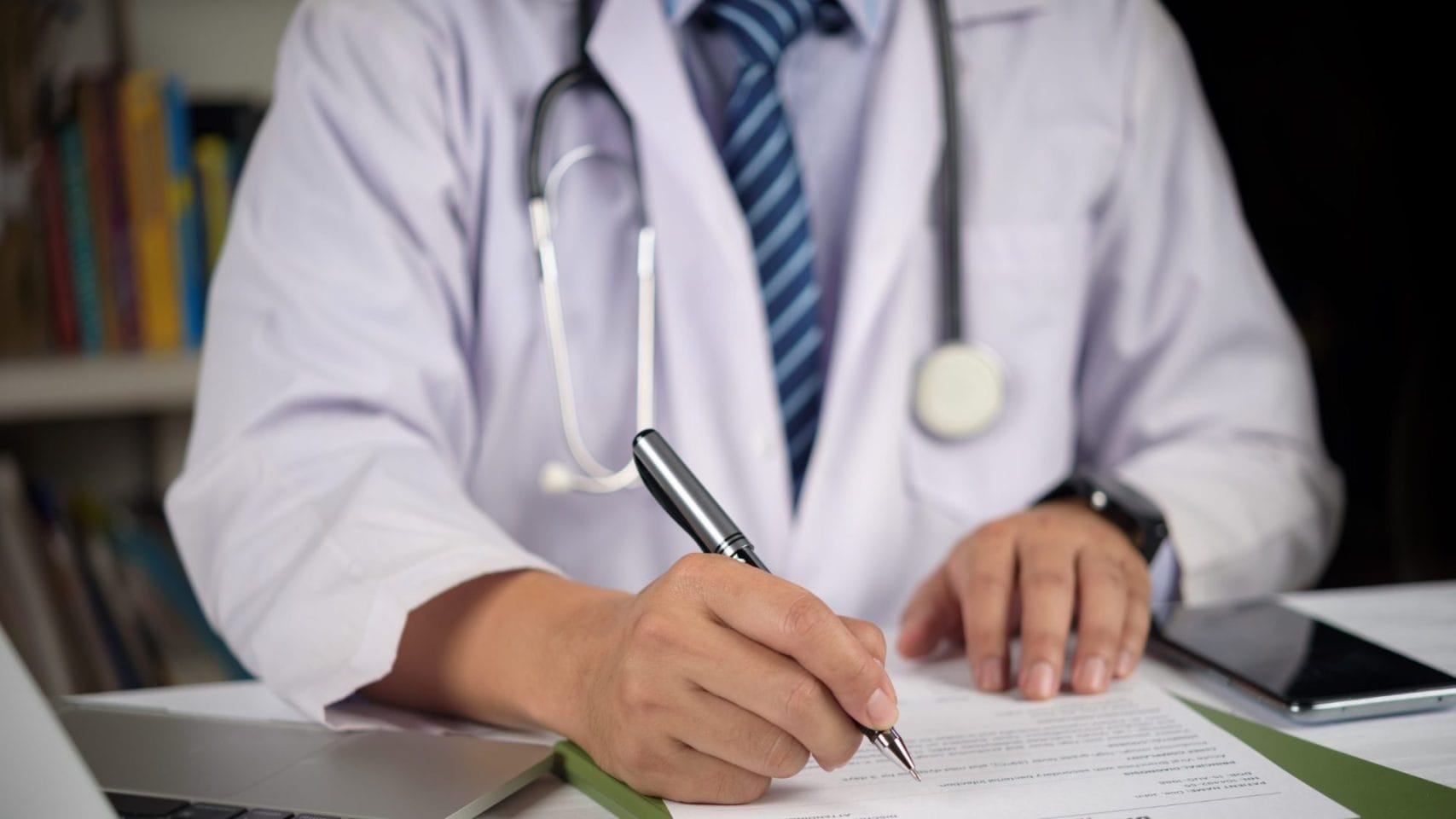 Doctor signing paperwork for a death certificate
