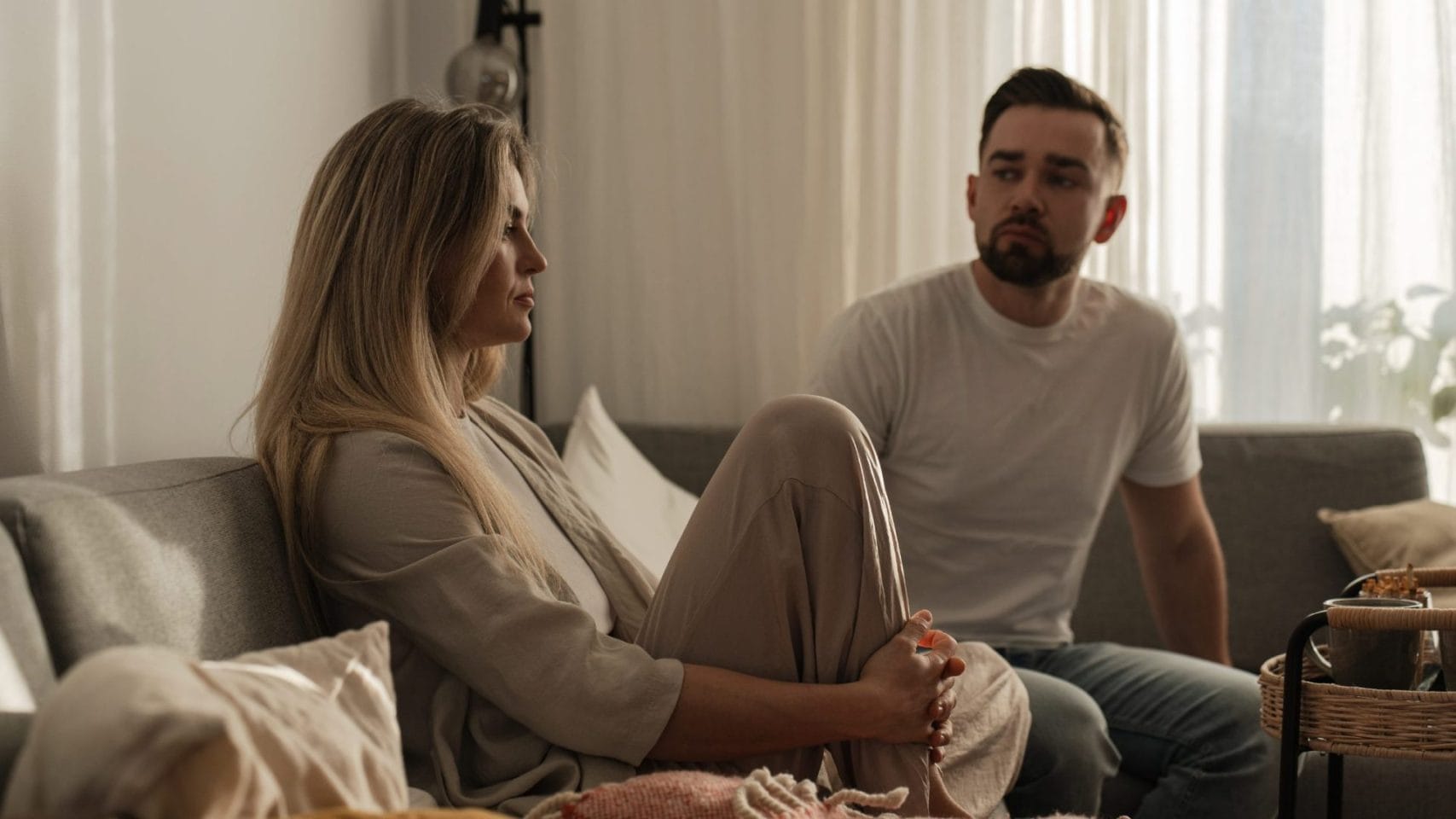 Two family members discussing cremation costs and arrangements at home.
