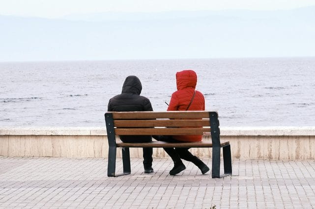 two people sitting together by the water reflecting after loss