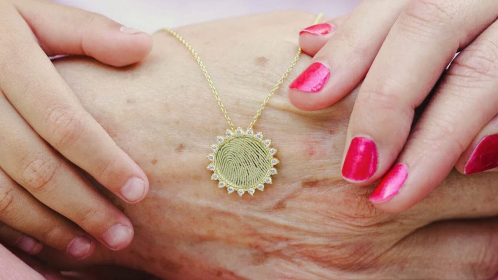 Fingerprint necklace held by family as a personalized memorial keepsake.