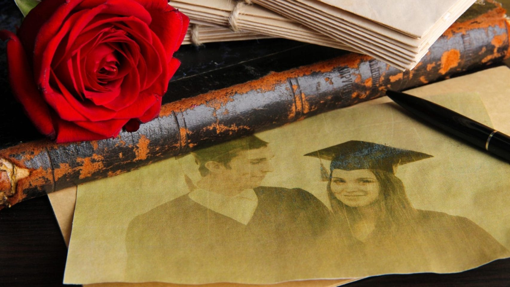 Rose, pen, and family photo used while writing an obituary.