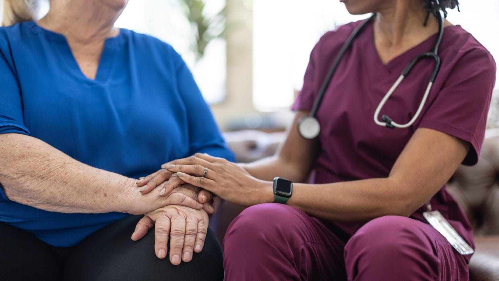 Hospice nurse comforting a family member during end-of-life care.