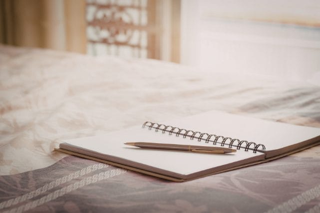 Notebook and pen representing information needed for cremation arrangements