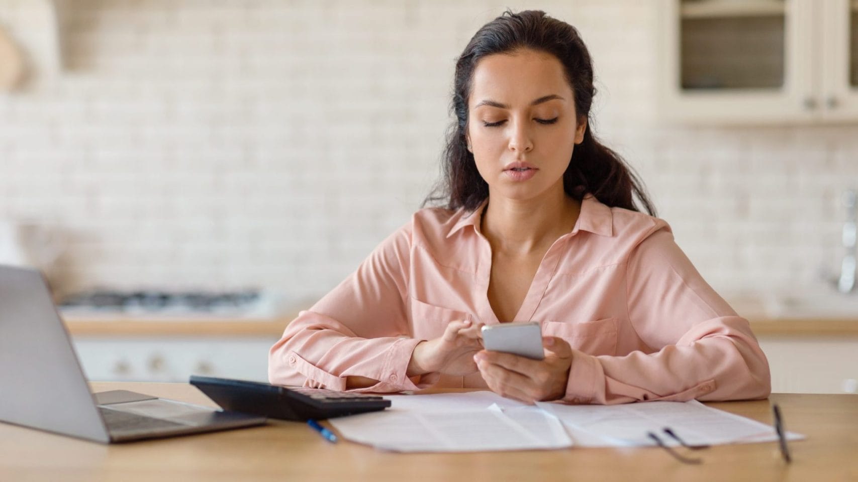 Woman using a laptop and phone to start cremation arrangements online in Katy TX