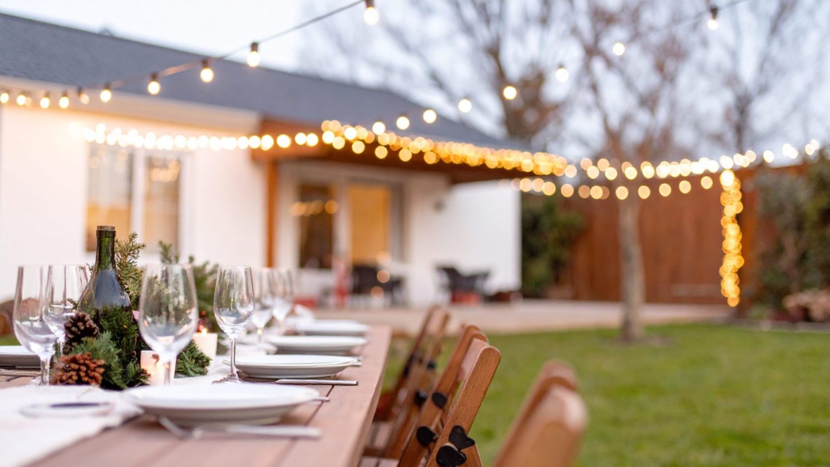 Outdoor table set for a celebration of life gathering with string lights