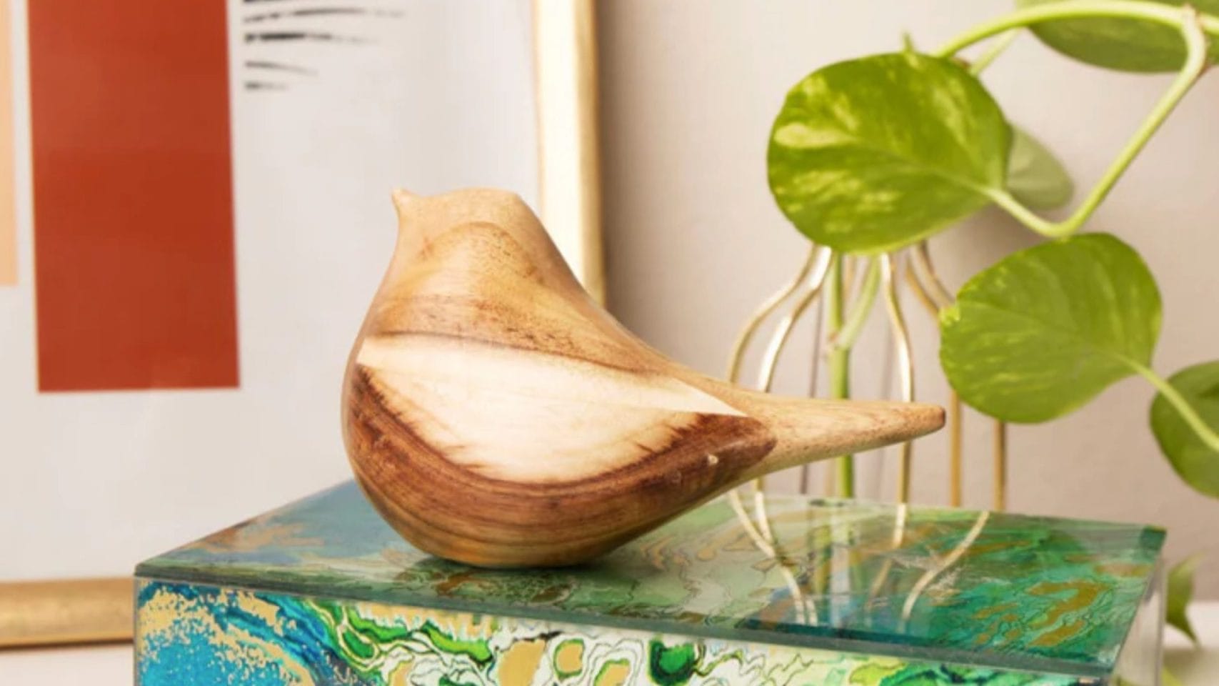 Small wooden bird-shaped keepsake displayed on a decorative box.