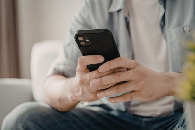 Person holding a phone while seeking guidance after a death at home in Houston